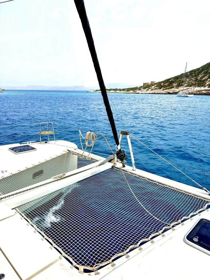Cabos aduchados e ferragens na proa de um catamarã.